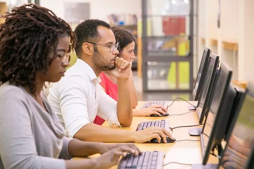 multiracial group of students training in computer class